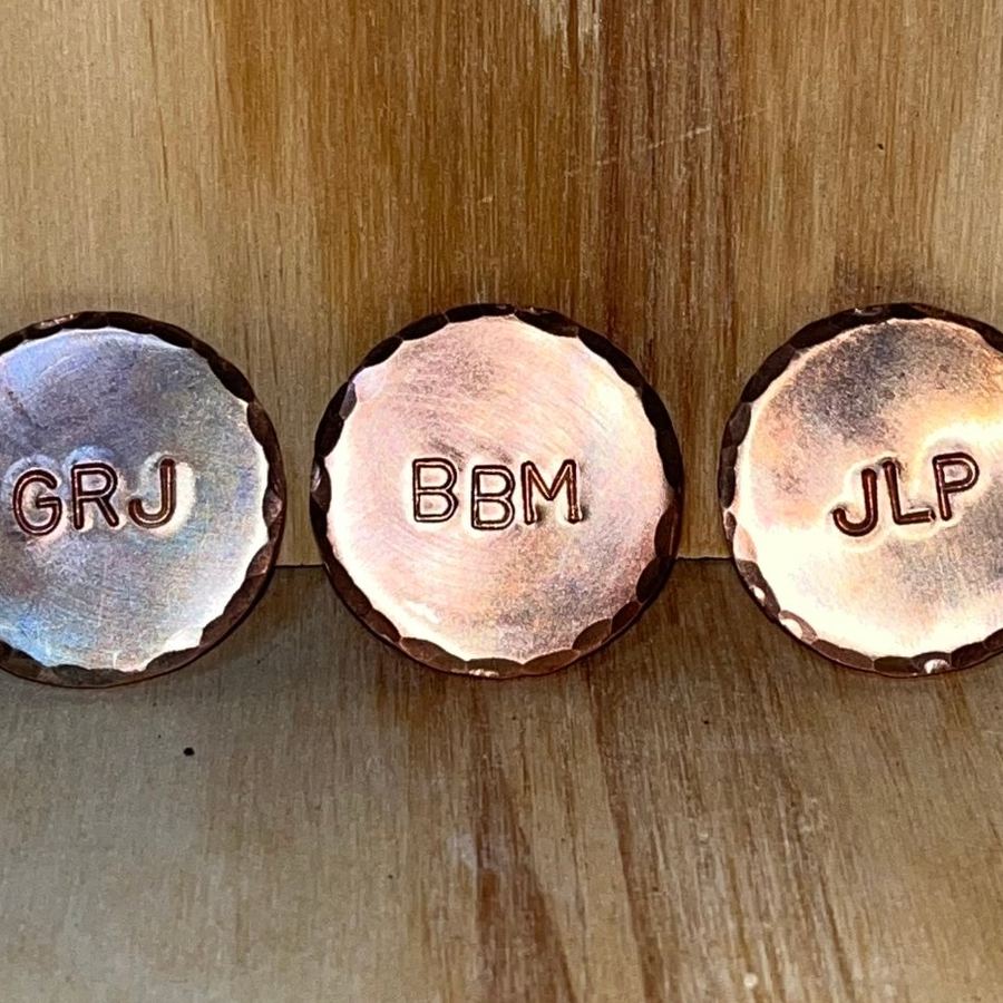 Copper markers stamped with initials